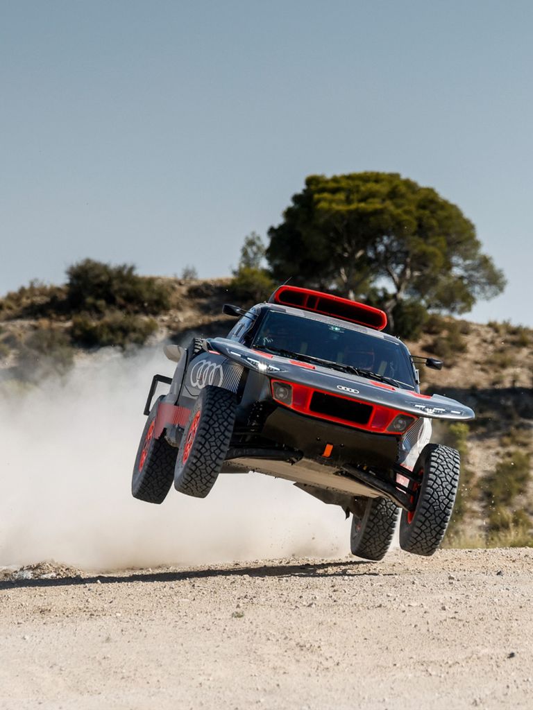 The Audi RS Q e-tron jumping over a gravel track.