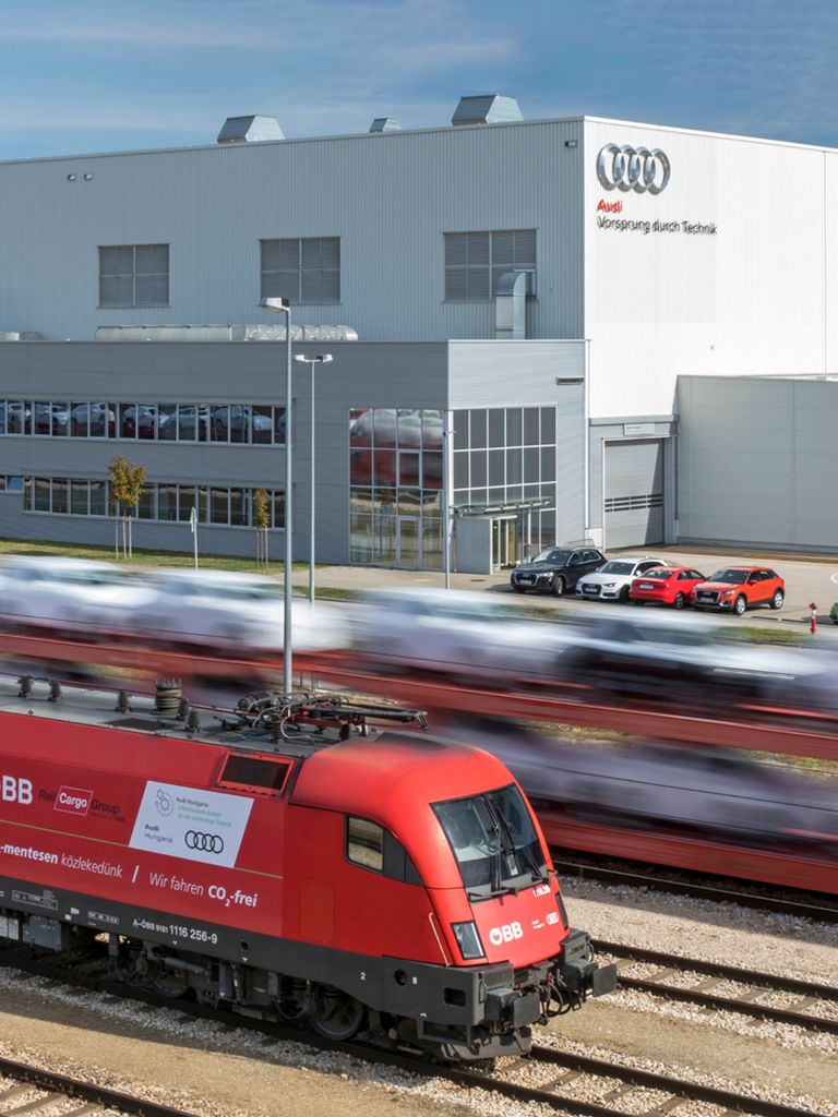 A freight train of the Austrian Federal Railways ÖBB in front of an Audi plant.