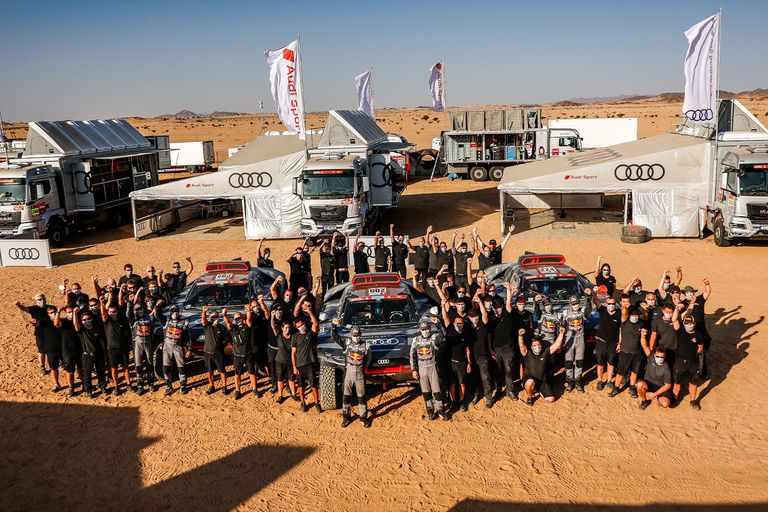 Group picture of the Audi Sport Dakar Rally team in the paddock