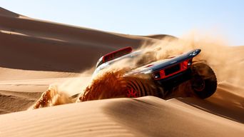 Audi RS Q e-tron driving over a sand dune.