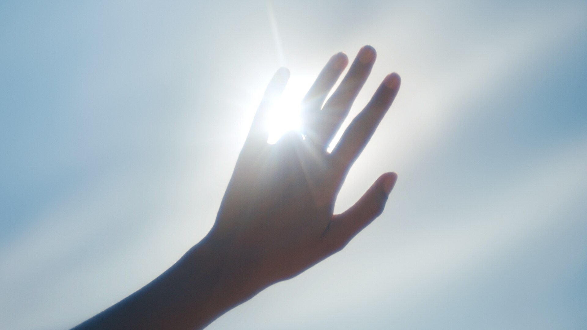 Sunlight flashing through the fingers of a hand.