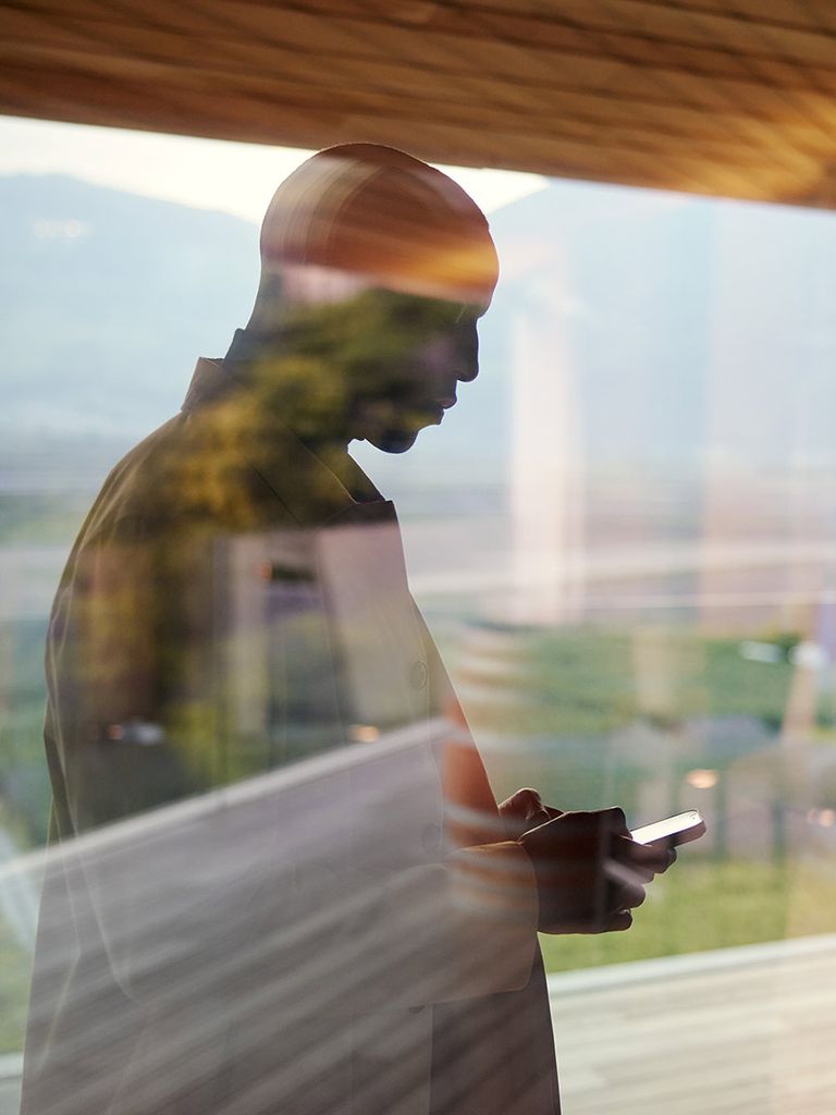 Man with a smartphone behind a window